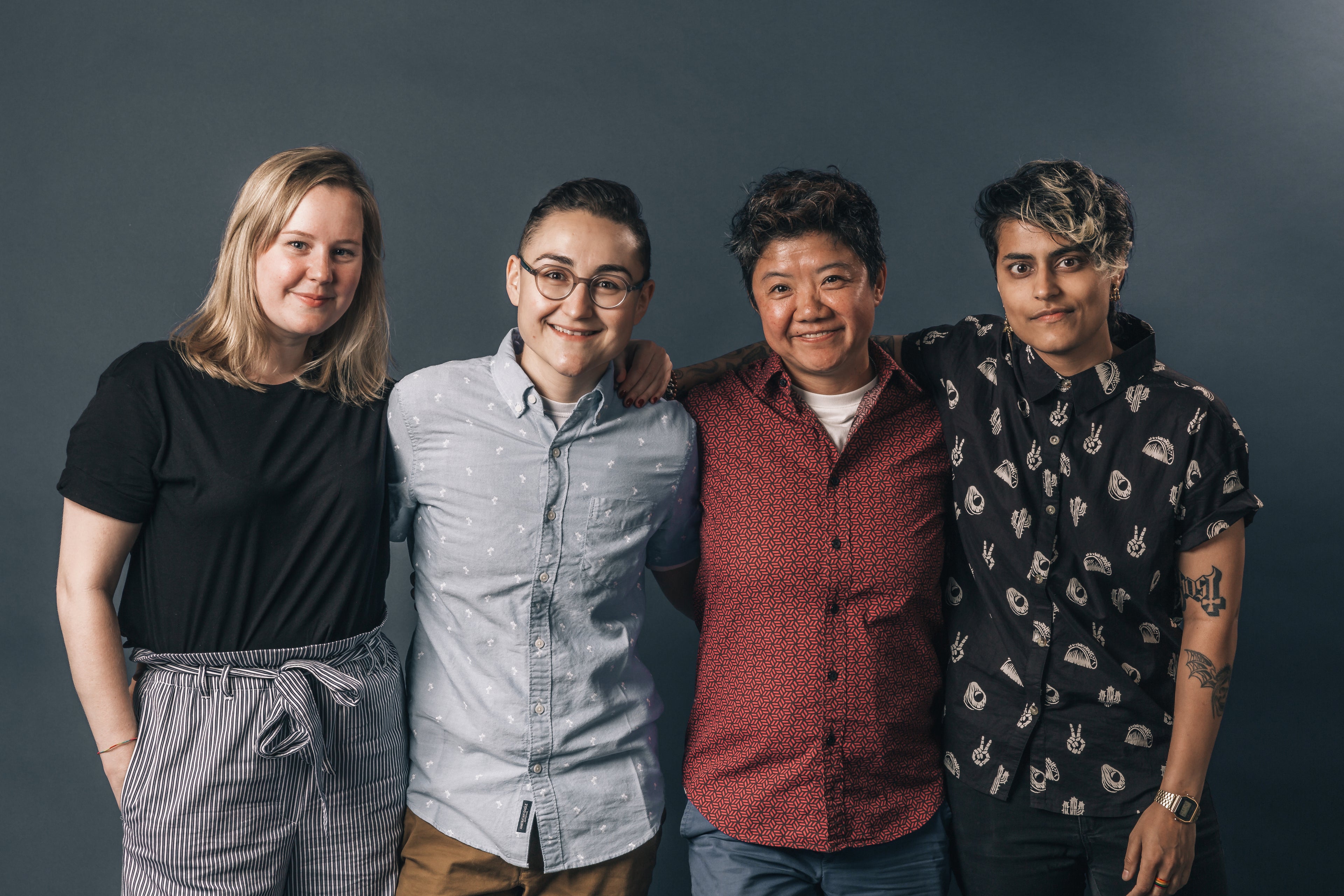 four people smiling, arm in arm, domestic violence support groups